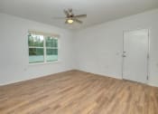 Thumbnail 17 of 40 - an empty living room with a ceiling fan and a window