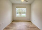Thumbnail 30 of 40 - an empty room with a window and a ceiling fan