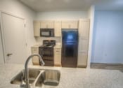 Thumbnail 24 of 40 - a kitchen with a sink and a black refrigerator