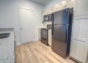 Thumbnail 25 of 40 - a kitchen with a refrigerator and a stove and