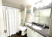 Thumbnail 18 of 46 - a bathroom with a shower toilet and a sink