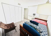 Thumbnail 22 of 46 - a bedroom with a bed and a chair