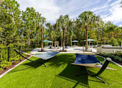 Thumbnail 47 of 60 - Relaxing hammocks at Longleaf at St. Johns Apartments, St. Johns, FL, surrounded by greenery