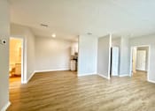 Thumbnail 10 of 16 - A large empty room with wooden floors and white walls.