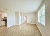 Thumbnail 5 of 16 - A spacious room with light wood flooring and white walls.