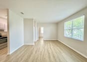Thumbnail 9 of 16 - A spacious room with light wood flooring and white walls.