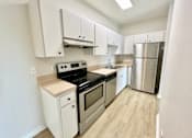 Thumbnail 13 of 16 - A kitchen with white cabinets and stainless steel appliances.