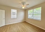 Thumbnail 3 of 16 - A room with a ceiling fan and two windows with blinds.
