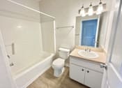 Thumbnail 15 of 16 - A white bathroom with a blue door.