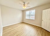 Thumbnail 14 of 16 - A room with a ceiling fan and wooden flooring.