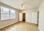 Thumbnail 6 of 16 - A room with a ceiling fan and a window with blinds.