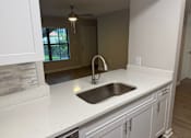 Thumbnail 58 of 75 - A kitchen with a white countertop and a stainless steel sink.