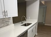 Thumbnail 63 of 75 - A kitchen with white cabinets and a stainless steel dishwasher.
