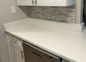 Thumbnail 67 of 75 - A kitchen with white cabinets and a washer and dryer.