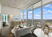 Thumbnail 3 of 114 - Spacious living room with floor-to-ceiling windows offering panoramic city views at Med Center.
