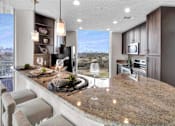 Thumbnail 2 of 114 - Modern kitchen with stainless steel appliances & sleek finishes at Med Center in Houston, TX.