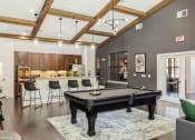 Thumbnail 34 of 35 - an open living room with a pool table and a kitchen with a bar