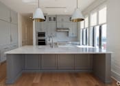 Thumbnail 40 of 40 - The Penthouse  A kitchen with a large island and pendant lights.