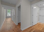 Thumbnail 14 of 22 - a renovated bedroom and hallway with wood floors and white walls at Spinning Mill Lofts, Clayton, NC 27520