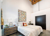 Thumbnail 3 of 8 - A bedroom with a large bed and a painting on the wall at Judson Mill Lofts, Greenville, SC 296110