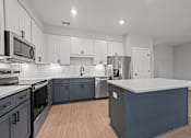 Thumbnail 20 of 30 - A modern kitchen with a large island and stainless steel appliances.at Regency Townes, Winterville, NC 28590  