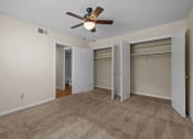 Thumbnail 8 of 10 - an empty living room with a ceiling fan and two closets