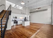 Thumbnail 18 of 22 - an open living room with a kitchen and a staircase at Spinning Mill Lofts, Clayton, NC 27520