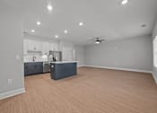 Thumbnail 19 of 30 - A spacious room with a kitchen area and wooden flooring.at Regency Townes, Winterville North Carolina  