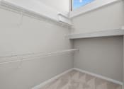 Thumbnail 21 of 22 - a spacious closet with shelves and a large window in a home with grey walls at Spinning Mill Lofts, Clayton, NC 27520