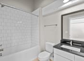 Thumbnail 22 of 22 - a white bathroom with a white toilet and a tub and a sink at Spinning Mill Lofts, Clayton, NC 27520