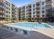 Thumbnail 44 of 63 - A large swimming pool in front of apartment buildings.
