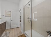 Thumbnail 10 of 63 - A bathroom with a walk-in shower and a plant on the counter.at Adler Montford Park + Drexel Townes, Charlotte, NC, 28209