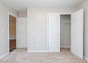 Thumbnail 16 of 21 - A white door is open to a room with a carpeted floor.