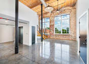 Thumbnail 5 of 8 - A large open room with a staircase and a window at Judson Mill Lofts, Greenville, SC