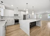 Thumbnail 18 of 63 - A modern kitchen with white cabinets and a large island.