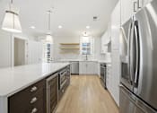 Thumbnail 19 of 63 - A modern kitchen with stainless steel appliances and wooden floors.