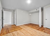 Thumbnail 15 of 22 - an empty living room with wood flooring and white walls at Spinning Mill Lofts, Clayton, NC 27520