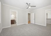 Thumbnail 28 of 63 - A room with a ceiling fan and carpeted floor.