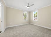 Thumbnail 26 of 63 - A room with a ceiling fan and two windows.
