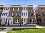 Thumbnail 14 of 63 - A row of brown and white townhouses with black railings.