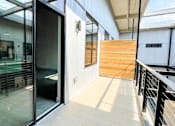 Thumbnail 4 of 8 - A glass door is open to a hallway with a wooden wall at Judson Mill Lofts, Greenville, SC 29611
