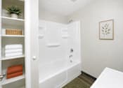 Thumbnail 3 of 13 - A white bathroom with a white tub and a white door.
