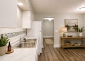 Thumbnail 1 of 13 - A kitchen with white cabinets and a marble countertop.