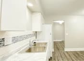 Thumbnail 6 of 13 - A kitchen with white cabinets and a stainless steel sink.