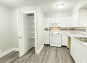 Thumbnail 7 of 13 - A kitchen with white appliances and cabinets.