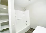 Thumbnail 9 of 13 - A white bathroom with a walk-in shower and a white table.