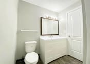 Thumbnail 8 of 13 - A white toilet sits next to a sink in a small bathroom.