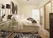 Thumbnail 5 of 13 - A bedroom with a white bed and a black and white rug.