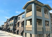 Thumbnail 5 of 16 - a row of townhomes with a blue sky in the background