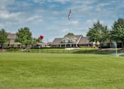 Thumbnail 12 of 14 - a large lawn in front of a the club house with a fountain